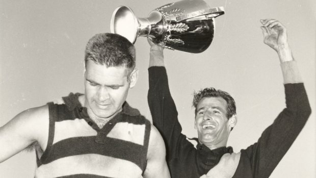 Polly Farmer (left) with hands on hips as Richmond captain Fred Swift holds aloft the 1967 VFL premiership cup. 