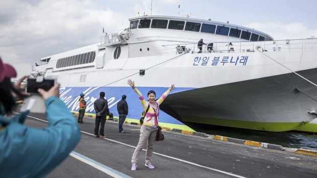 Tourists take photos in front of a South Korean ferry on the resort island of Jeju.