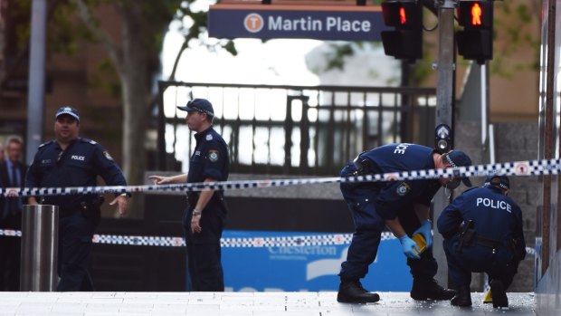 Seeking evidence: Forensic police officers mark out the Martin Place crime scene after the siege ended.