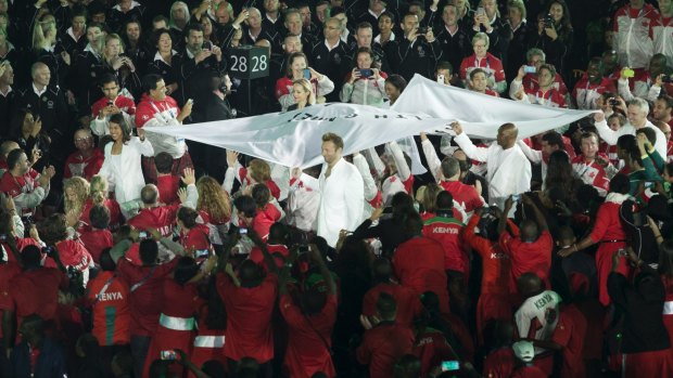 Ian Thorpe carries the Commonwealth Games flag.