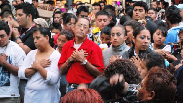 People praying during a service to Santa Muerte on Alfareria Street in Mexico City.
