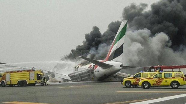 Crews work to extinguish a fire on Emirates flight EK521 after it was involved in an accident.