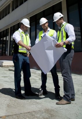 Sasha Mielczarek (right) working in 2013 on a project to  convert  the old Juliana House in Woden into a hotel.