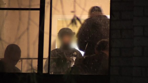 Police are seen inside a house during a raid in Sydney, in this still image taken from a police handout video on September 18, 2014. 