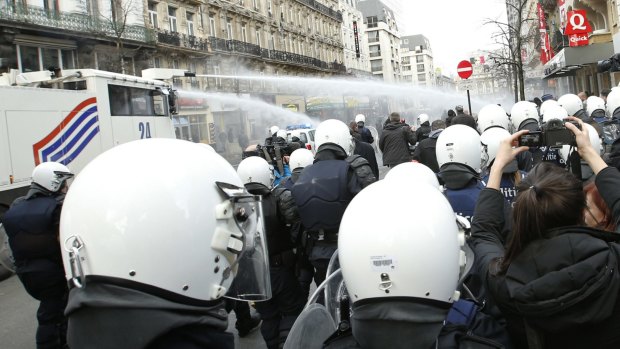 Police use water cannon to try to disperse demonstrators at the site of one of the memorials to the victims of the recent Brussels attacks.