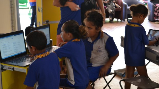 Children checking out laptops at the launch of State Library of Queensland's Ideas Box.