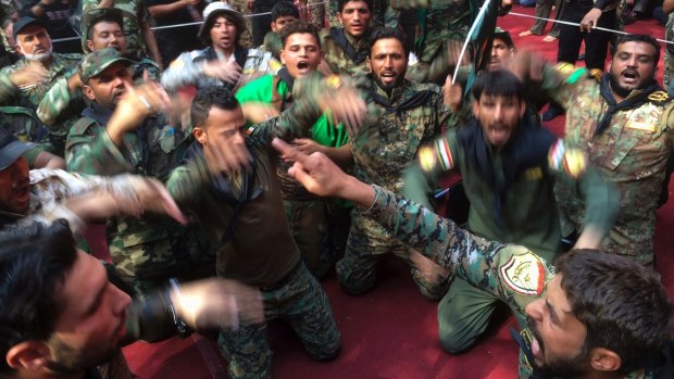 Members of the Shiite Popular Mobilisation forces mourn during Shiite rites of the month of Muharram inside the shrine of Imam Abbas in Karbala, Iraq, in October.