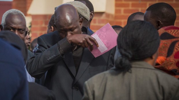 The children's father Joseph Tito Manyang at their funeral on Saturday.
