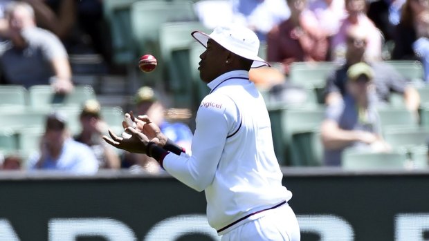 A case of the fumbles: West Indies' Marlon Samuels juggles a catch to dismiss Australia's David Warner early on day one. Samuels would drop a sitter late in the day.