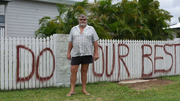 Graham Wilson with the defiant message on his fence for Cyclone Debbie.