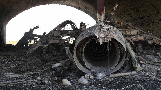 The aftermath: a plane destroyed in the US missile attack on a Syrian air base.