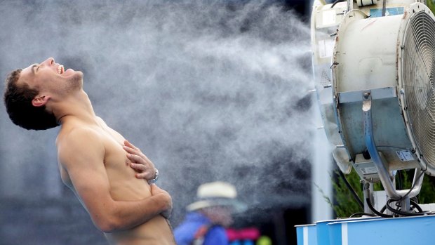 Jerzy Janowicz of Poland stands in front of a misting fan at this year's Australian Open.