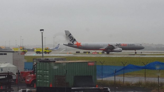 Fire trucks drive to meet a Jetstar flight that was turned back to Sydney Airport on Sunday afternoon.