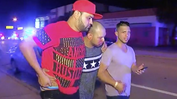An injured man is escorted out of the Pulse nightclub.