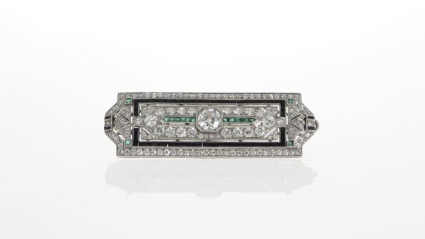 A Rutherford of Melbourne Art Deco platinum brooch featuring a transition-cut diamond, onyx and emeralds.