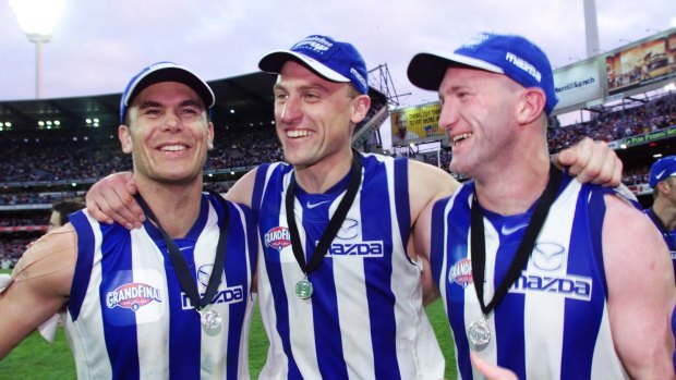 Teammates: Longmire celebrates the 1999 premiership with Wayne Carey and Mick Martyn
