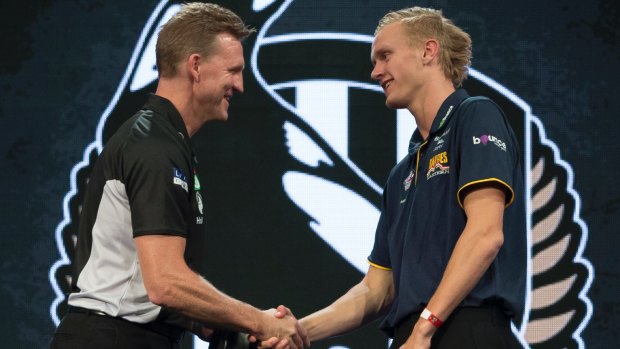 Jaidyn Stephenson of the Eastern Ranges is presented with his guernsey by Collingwood Magpies coach Nathan Buckley. 