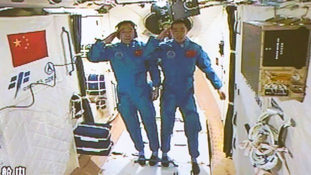 Chinese astronauts Jing Haipeng, left, and Chen Dong salute after entering the space lab Tiangong-2.