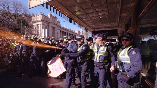 Police use pepper spray at the protest in Melbourne.