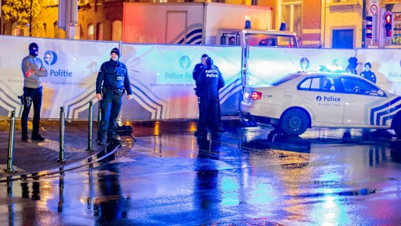 Belgian police guard a street in Brussels where arrests linked to the Paris attacks were made.