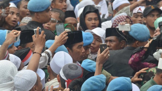 Indonesian President Joko Widodo, centre, is photographed as he joins the demonstrators on December 2. 