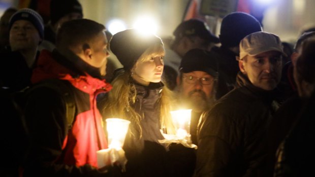 Protesters hold candles as they attend a Pegida demonstration in Dresden.
