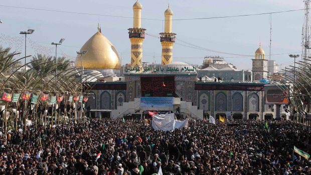 Shiite worshippers gather between the holy shrines of Imam Abbas, seen in the background, and Imam Hussein, for Arbaeen in Karbala, south of Baghdad on Sunday.