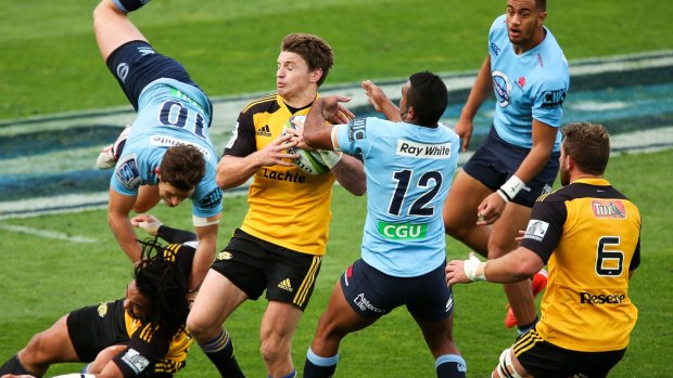 Duel:  Beauden Barrett of the Hurricanes gathers a loose ball while Bernard Foley of the Waratahs collides with Ma'a Nonu. Barrett went on to score a try, but Foley won the war.