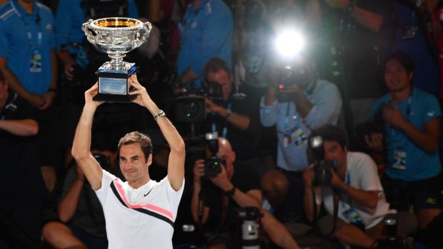 Roger Federer holds the trophy aloft inside the Rod Laver Arena.