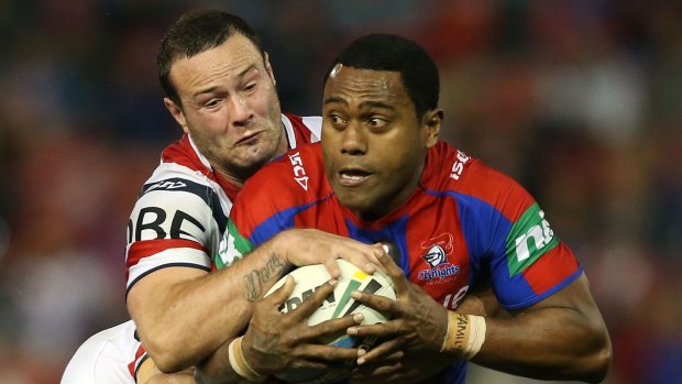 Akuila Uate, right, of the Knights is tackled by the Roosters defence during the round 22 NRL match agasinst the Roosters at Hunter Stadium on August 9.
