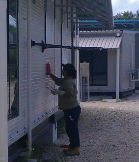 A worker removes graffiti that likened the Australian Border Force to Nazi forces.