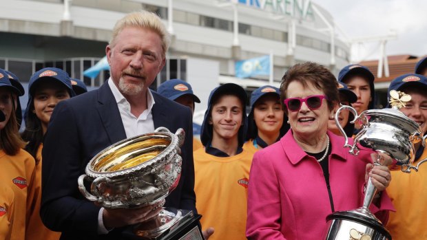 Former champions Boris Becker and Billie Jean King hold the men's and women's trophies at the Australian Open.