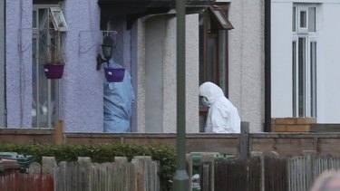 Forensic officers enter the home in southwest London for clues, following the arrest on an 18-year-old man on Saturday.