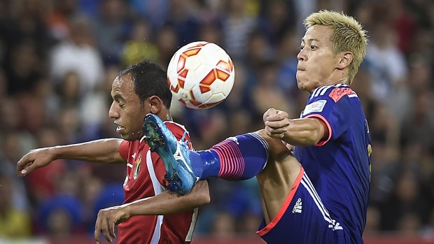 Jordan's Monther Abu Amara and Japan's Keisuke Honda compete for the ball during the Asian Cup match on Tuesday.