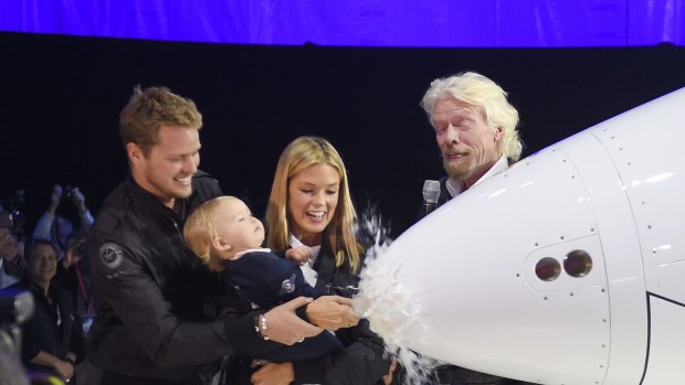 Sam Branson, left, and his wife Isabella help their daughter Eva-Deia christen the space ship.