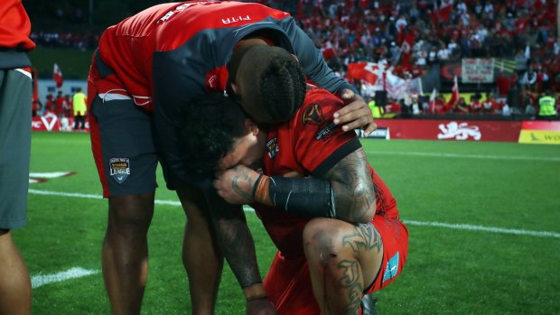 Distraught: Andrew Fifita is consoled at full-time, just moments after he lost the ball with the try line begging.