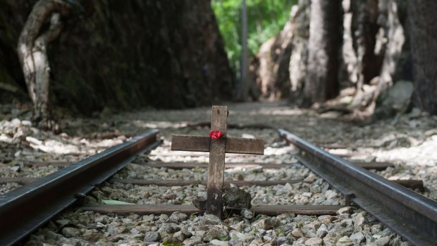 A remembrance wooden cross and red poppy along a section of railway at Hell Fire Pass railway cutting.
