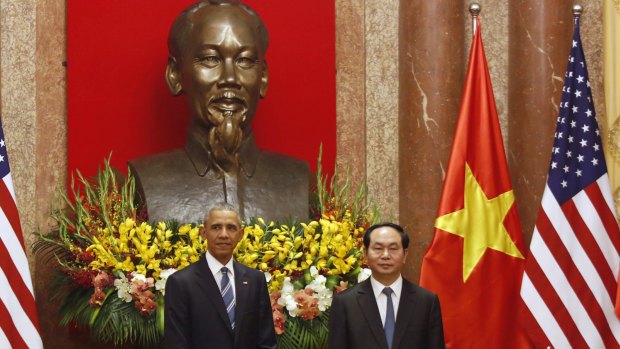 US President Barack Obama, left, stands next to Vietnamese President Tran Dai Quang under a bust of Vietnamese revolutionary leader Ho Chi Minh at the Presidential Palace in Hanoi on Monday.  