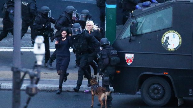 Hostages run to safety as police storm the grocery store. 
