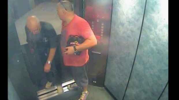 Glen McNamara, holding a six pack of beer under his arm, with Roger Rogerson in the lift of Nr McNamara's Cronulla apartment on May 20, 2014. 