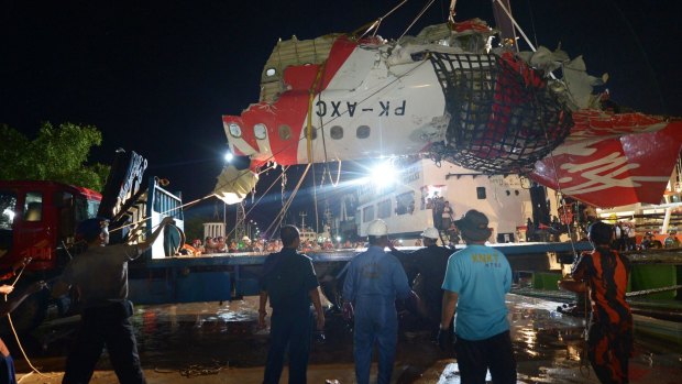 The tail section of the Air Asia  flight QZ8501 is prepared to be loaded onto a truck at port in Kumai, Indonesia.