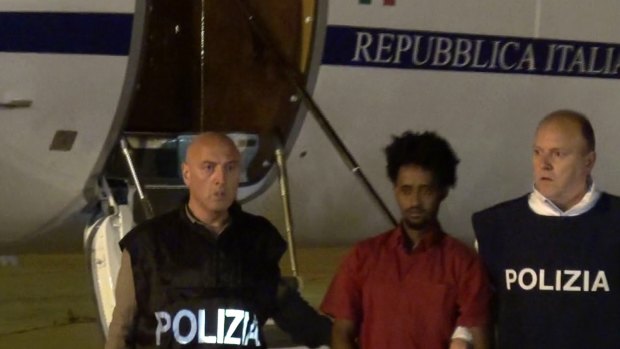 Italian police with the man they believe to be "the General", wanted people smuggler Medhanie Yehdego Mered, in June. A court has heard claims that it is a case of mistaken identity.