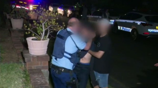 Police and partygoers outside the Gladesville home on Saturday night.