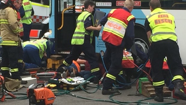 Emergency services working to free the man trapped under a bus in Parramatta. 