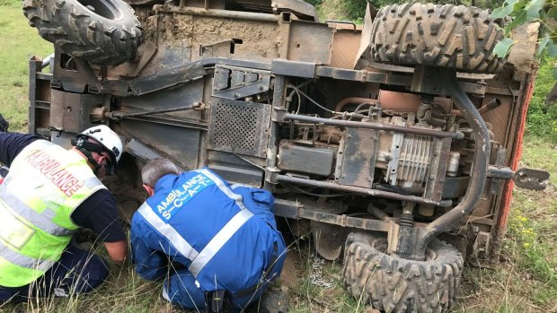 Ambulance officers inspect the vehicle which trapped Georgia's mum Natalie after it flipped on the family's farm near Taree. 