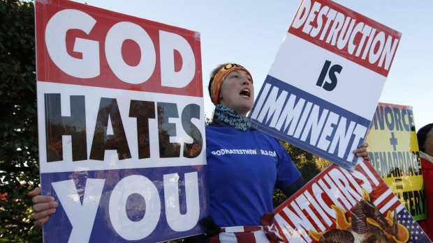 Members of the American Westboro Baptist Church hold anti-gay signs at a protest.