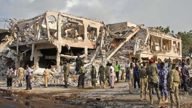 Somali security forces and others gather and search for bodies near destroyed buildings at the scene of Saturday's blast in Mogadishu.