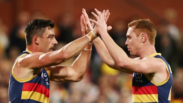 Crows Taylor Walker congratulates Tom Lynch on kicking a goal.