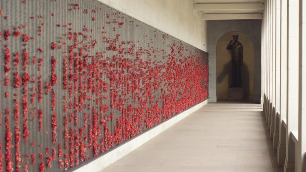 Poppies left by visitors to the Australian War Memorial splash the Wall of Remembrance
with red.