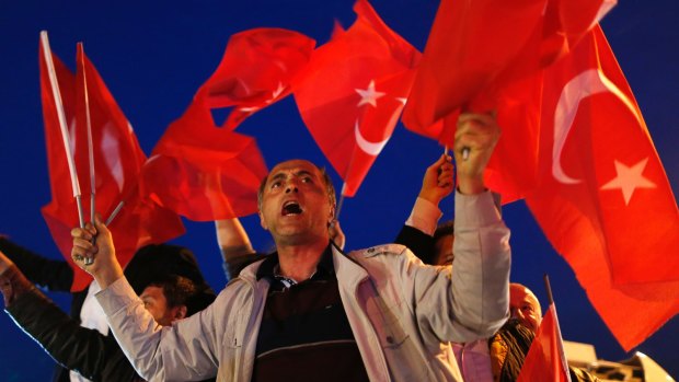 A supporter of the "Yes" vote, waves Turkish flags during celebrations in Istanbul.